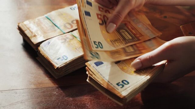 Hands of a woman counting many 50-euro bills. Woman counts banknotes salary or unemployment benefit.