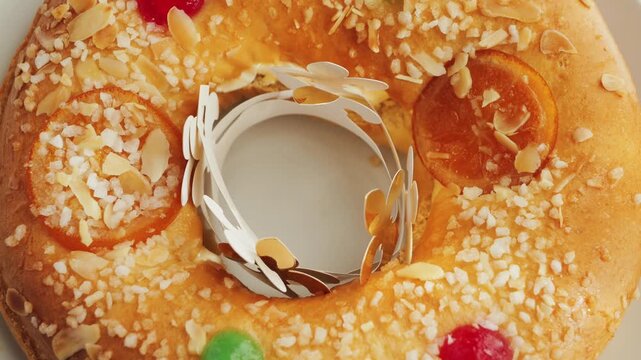 A sweet cake Roscon de Reyes dessert topped with almonds and candied fruit.