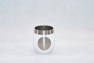 White stainless steel mate cup with lid isolated on white background. Modern reusable container for traditional South American drink, clean product photography with copy space.