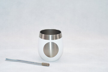 White stainless steel mate cup with lid isolated on white background. Modern reusable container for traditional South American drink, clean product photography with copy space.