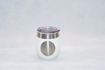 White stainless steel mate cup with lid isolated on white background. Modern reusable container for traditional South American drink, clean product photography with copy space.