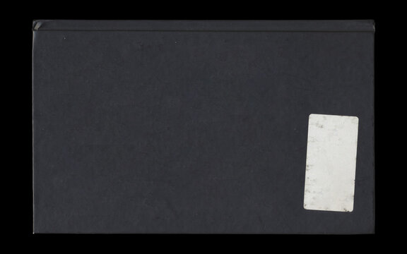 Black book cover back view with blank sticker label isolated on black background