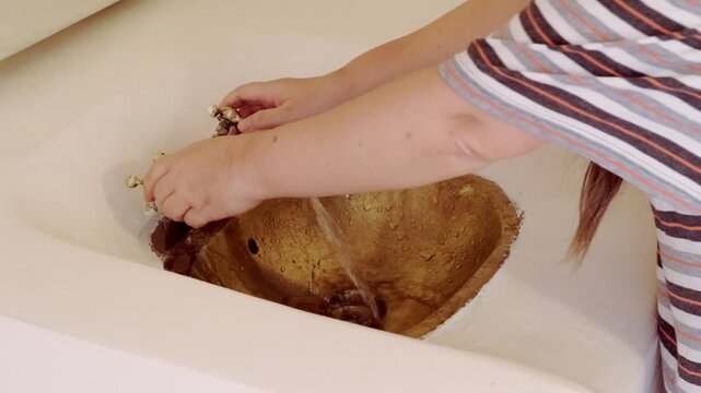 washing hands in Rustic brass sink, morning skincare routine in Moroccan-style interior, Self-care and mindfulness, basic hygiene and cultural touch in Morocco