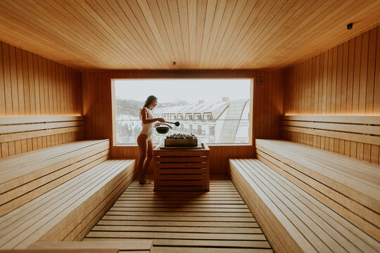 Woman using sauna with a view of the snowy outdoors in a wellness center