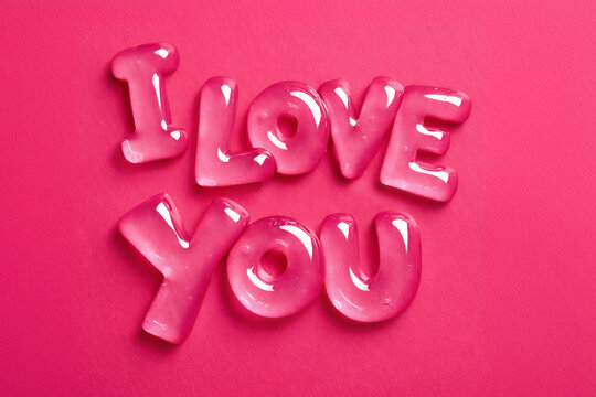 Glossy pink letters spelling love on vibrant pink background. Playful typography, candy-like texture, bold color focus, graphic still life expressing affection and celebration. Valentines Day concept