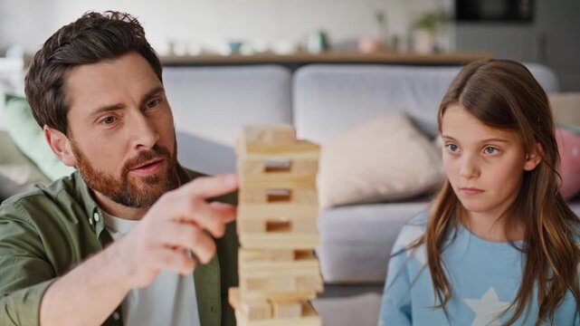 Parent child enjoy game building tower wooden blocks in living room closeup