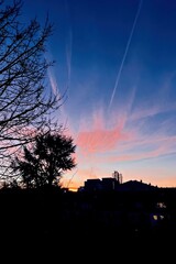 Naklejka premium Colorful Sunset Sky Over Buildings and Trees in the Evening
