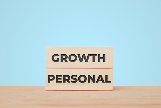 Personal Growth Concept with Wooden Blocks on Light Blue Background