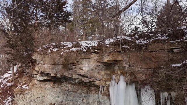 Left to right drone shot of rocky stone bluff of limestone and dolomite. 