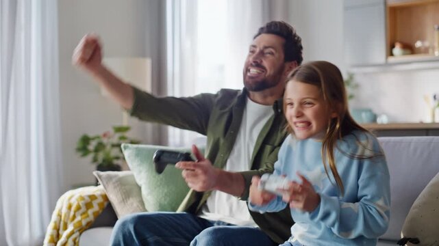 Emotional daughter father playing online game sitting home couch closeup. 