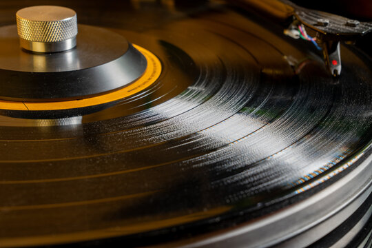 Closeup View black shiny record player with rotating vinyl and record clamp
