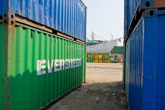 Jakarta Indonesia - 20 July 2025 - Stacked sea containers in the old harbor Sunda Kelapa with wooden cargo ships in Jakarta Indonesia