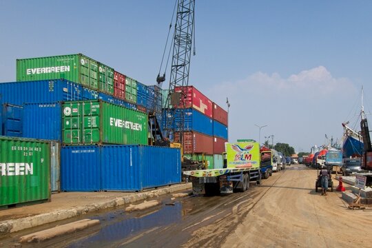 Jakarta Indonesia - 20 July 2025 - Stacked sea containers in the old harbor Sunda Kelapa with wooden cargo ships in Jakarta Indonesia