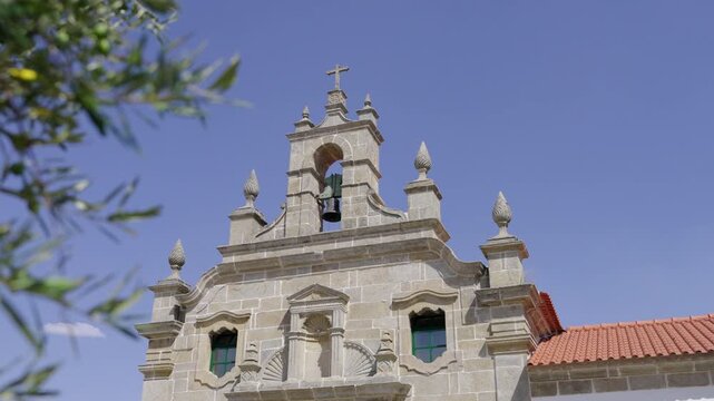 Church (Igreja da Misericordia, Miranda do Douro, Portugal) from the outside with an olive tree in the foreground.