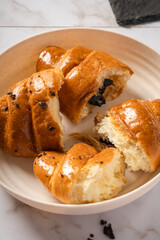 Top view of sliced ​​chocolate filled croissant pastry on a white plate. Delicious French breakfast.