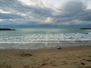 Dramatic storm clouds over calm Mediterranean Sea at Cubelles beach, Spain