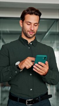 Middle-age manager using cell phone mobile application. Digital technology application for business communication. Smiling young CEO Latin businessman trader holding smartphone in office. Vertical