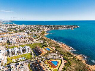 Aerial view Cabo Roig coastal town on southern Costa Blanca, Mediterranean Sea and seafront residential buildings during sunny day. Province of Alicante. Spain