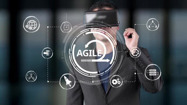 A businessman wearing virtual reality goggles stands amidst digital technology symbols, representing the concepts of innovation, agility, and transformation in today work environment. Raster