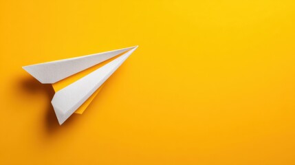 White paper airplane flying on yellow background