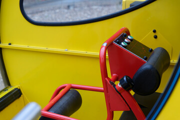 Yellow wall with oval window and metal lever control panel.