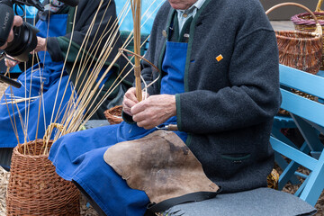 Demonstration of old traditional hand-made basket weaving with long dry grass in Vienna at festival, Austria