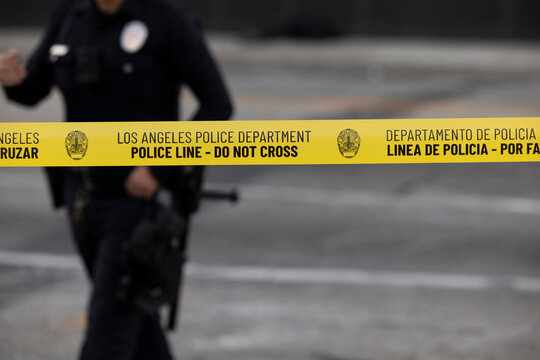 Los Angeles, California, USA - January 31, 2026: An LAPD officer walks behind cordon tape securing the scene of an incident.