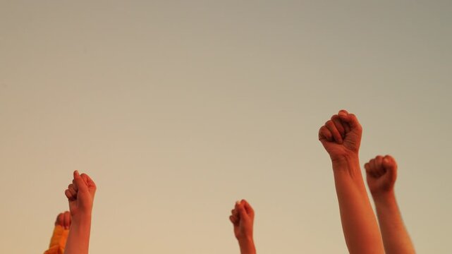 Group of people on background horizon raises their fists up. Raise your fists in sign equality. Teamwork businessmen. Vote, make your choice, express your opinion, support freedom. Victory persons