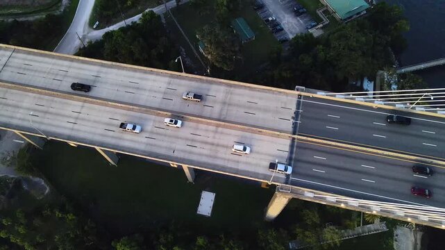 Vehicles crossing a suspension bridge over wide river in Florida
