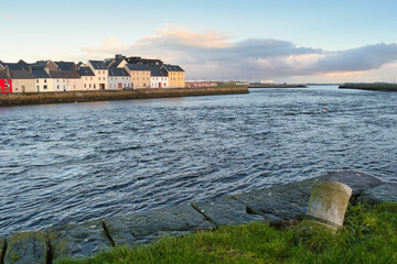 Obraz premium Colorful houses along the Long Walk by Corrib River at sunset in Claddagh, Galway city, Ireland, Wild Atlantic Way travel background