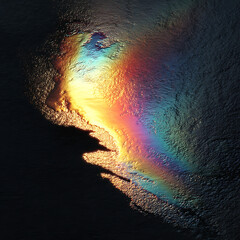 Fototapeta premium Vibrant Iridescent Oil Spill Pattern on Dark Liquid Surface Featuring a Spectrum of Rainbow Colors and Fluid Textures for Environmental and Creative Concepts.