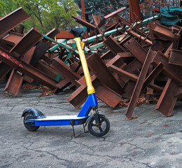 A scooter against the backdrop of iron anti-tank hedgehogs