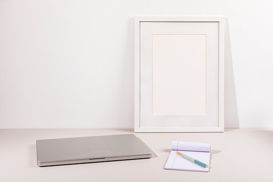 Laptop on gray surface with white wall