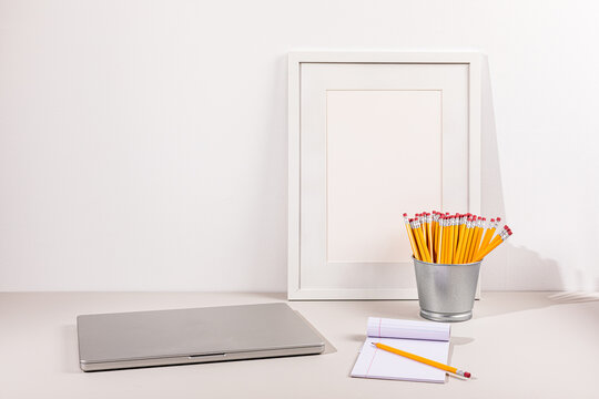 Laptop on gray surface with white wall
