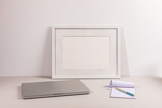 Laptop on gray surface with white wall