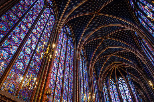 interior of Sainte-Chapelle in Paris featuring towering stained glass windows and a starry vaulted ceiling. Iconic Gothic architecture and medieval French royal heritage in France