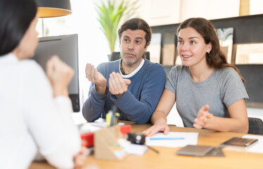 Fototapeta premium Married couple discusses the terms of purchasing a new kitchen set with a furniture store manager