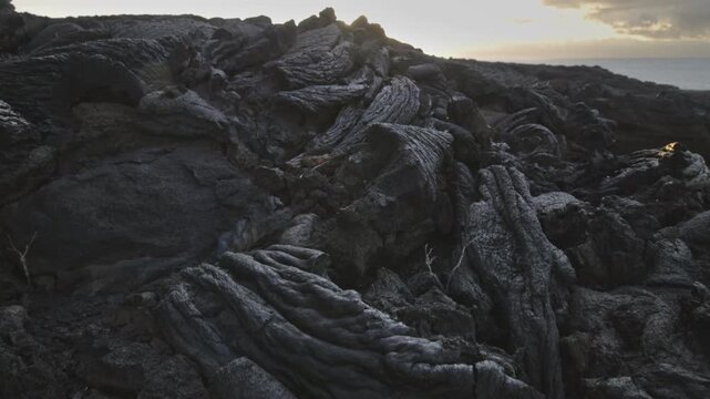 Breathtaking sunrise over vast volcanic lava field with golden sun rays hitting the black rocks. El Hierro, Canary Islands, Spain. Black solidified lava after volcanic eruption