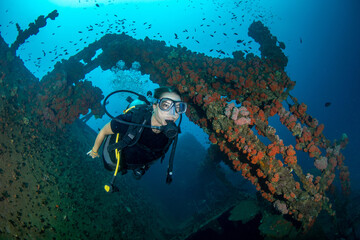 Woman scuba diving on shipwreck with reef fish, Colombo, Sri Lanka © Krzysztof Bargiel