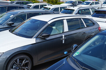 Rows of new cars parked closely together at a vehicle storage lot awaiting delivery or sale