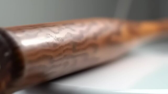 Wooden baseball bat on white surface.