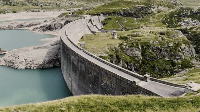 Panning view of Montespluga Lake dam - Alpine landscape and drought in Italy