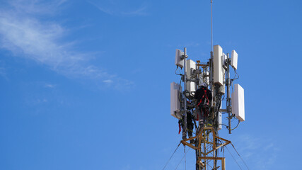 Worker installing advanced mobile network technology on a telecommunication tower, ensuring global connectivity and next generation services
