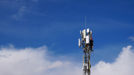 Obraz premium Blue collar worker performing maintenance on a cellular network tower, upgrading mobile technology infrastructure for fast internet