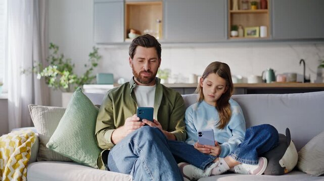 Father girl involved smartphones sitting relaxed couch. Happy father discussing 