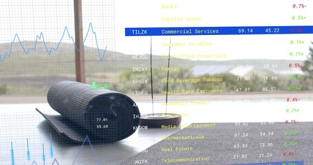 Naklejka premium Resting rolled gray yoga mat near window in sunlit room, with strap, round speaker, market charts