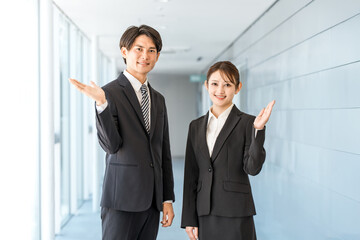 Fototapeta premium おすすめ,紹介,案内,提案するスーツ姿の若いアジア人ビジネスマン男女
