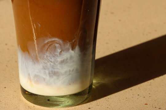 Cream settled at the bottom of a glass.