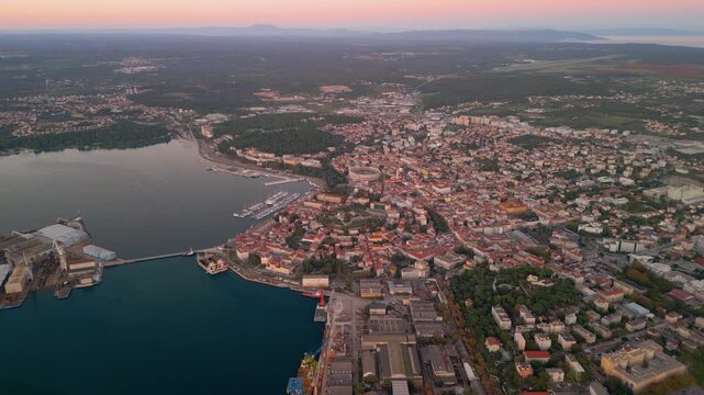 Epic Pula arena sunset aerial flight. 
Cinematic 4K drone forward flight over 
historic Roman amphitheater and Grand Harbour 
at twilight in Pula, Croatia.
