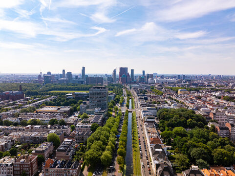 High angle view of The Hague city featuring modern buildings, green spaces, a canal and parked cars on a sunny summer day in Holland